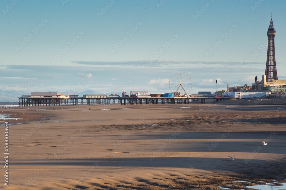 Beautiful view of Central Pier and the Blackpool Tower on the shoreline with clouds in background