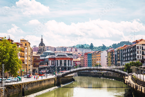 Bilbao city with the Ribera Market, the colorful architecture and the Nervion river on a sunny day. Enjoying a nice vacation in the Basque Country, Spain © AdriaVidal