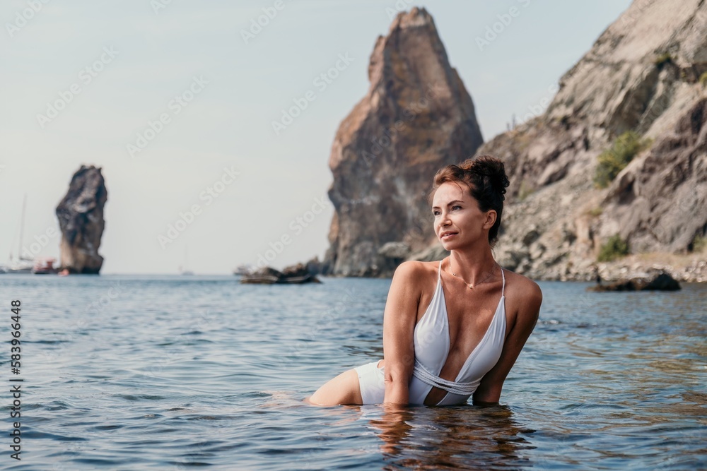 Woman sea fitness. Happy woman in a white bikini performing pilates in the sea on the beach. Female fitness yoga routine concept. Healthy lifestyle. Woman sea fitness. Happy woman in a white bikini performing pilates in the sea on the beach. Female fitness yoga routine concept. Healthy lifestyle.
