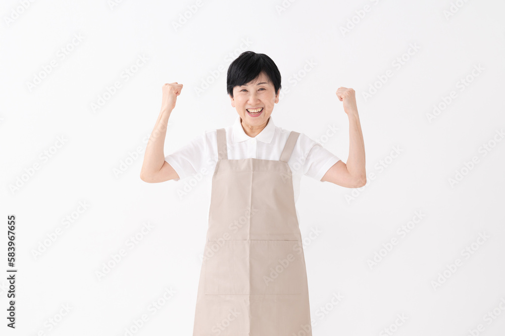 ガッツポーズをするエプロン姿の女性
