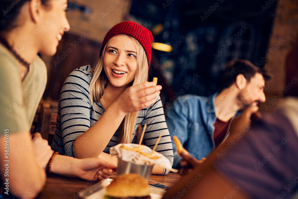 Young woman has fun while being with her friends in pub.