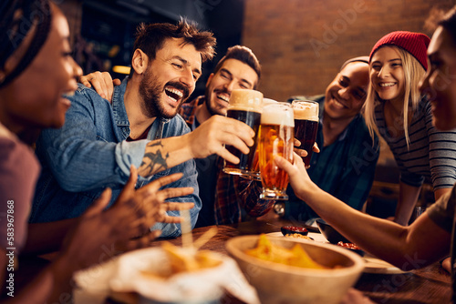Stampa su tela Multiracial group of happy friends has fun while toasting with beer in pub