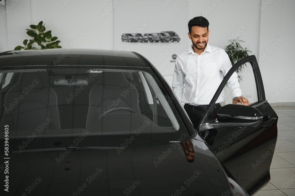 happy indian man checking car features at showroom happy indian man checking car features at showroom