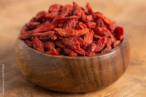 A Bowl of Red Dehydrated Goji Berries in a Wooden Bowl in the Kitchen