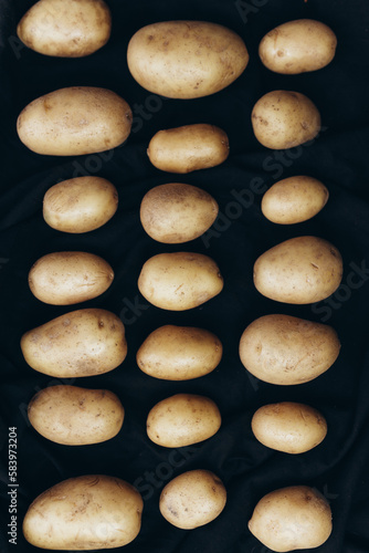 Potatoes in a raw on a black background