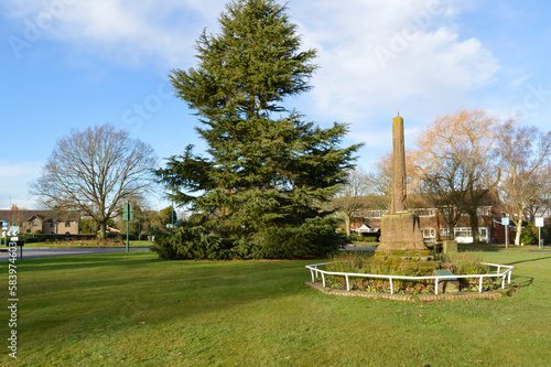Old sandstone pillar-shaped monument in Meriden village stands on the green grass photo