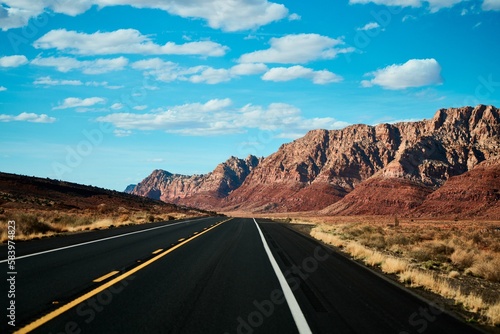 Straight desert road under blue sky on a sunny day in Arizona, United States