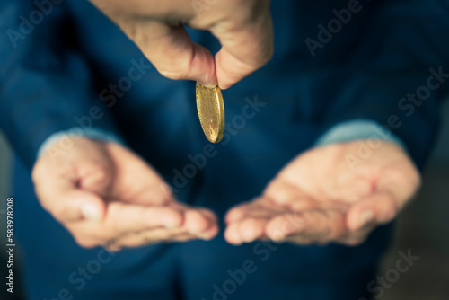 concept of charity. A businessman gives a gold coin to a businessman. Businessman give money to partner.