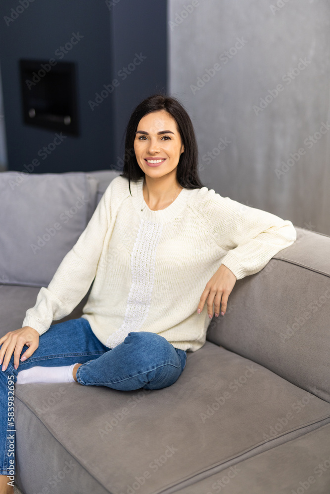 Beautiful young woman with laptop resting on couch at home Beautiful young woman with laptop resting on couch at home