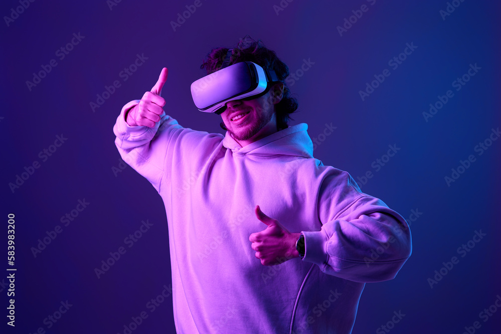 man in vr glasses and sweatshirt plays on blue background. man in vr glasses and sweatshirt plays on blue background.