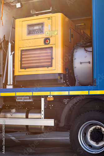 Yellow generator installed on service truck to power the reserve equipment. electric backup generator in body of special vehicle.