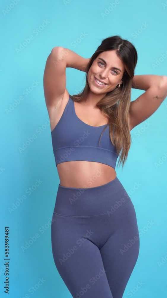 Smiling sportswoman with hands on waist in studio. Vertical video. Smiling sportswoman with hands on waist in studio. Vertical video.