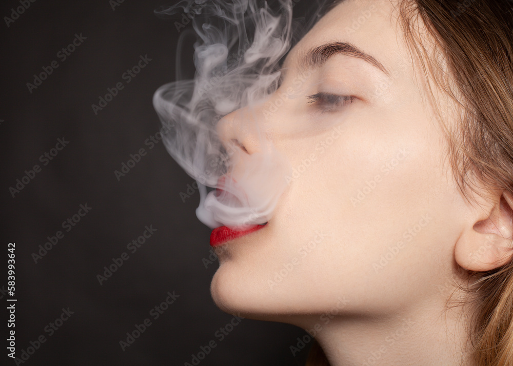 a woman with red lipstick on her lips lets out thick smoke a woman with red lipstick on her lips lets out thick smoke