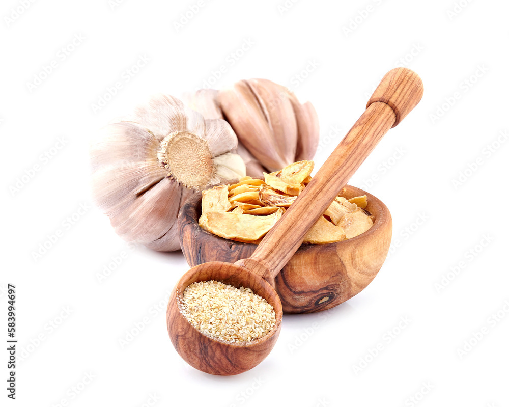 Garlic in closeup on white background. Garlic powder in wooden spoon. Garlic slices. Garlic in closeup on white background. Garlic powder in wooden spoon. Garlic slices.