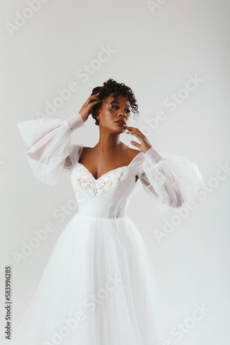 Beautiful African American woman posing in a wedding dress. Fashion model in a white dress.