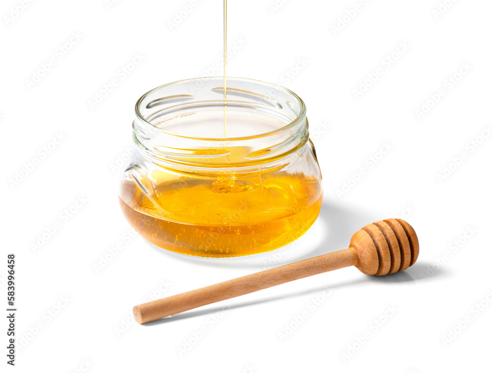 Honey is poured into an empty jar on a white background. Honey is poured into an empty jar on a white background.