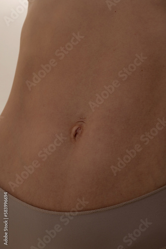 Young woman with naked belly. Close-up of a woman's belly.