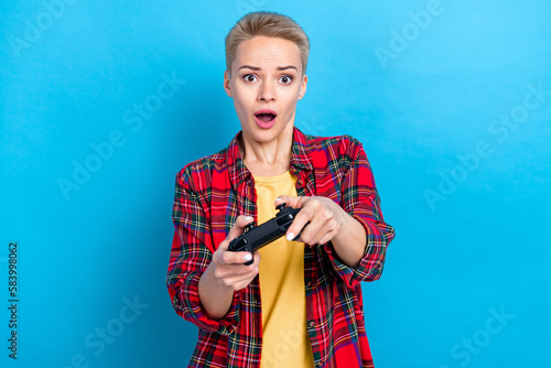 Photo poster promo blonde hairdo woman wear casual red stylish shirt open mouth scared addicted controller game isolated on blue color background © deagreez