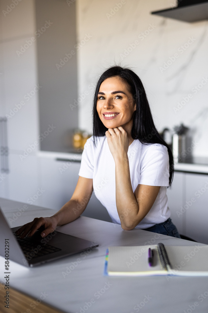 Cute smiling woman using laptop at home. Student girl working on computer. Online shopping, work from home, freelance, online learning, studying, lockdown concept. Distance education