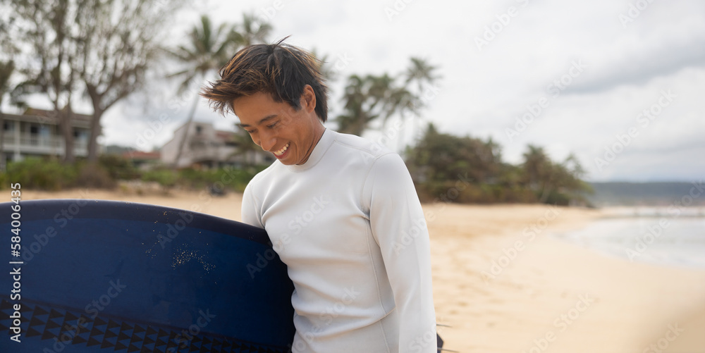 Happy man surfer on the beach with a surfboard. Smiling, Walking