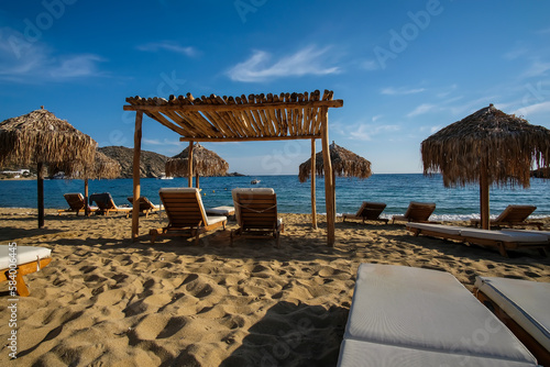 View of luxury sun beds and sun umbrellas at the famous Mylopotas beach in Ios Greece photo