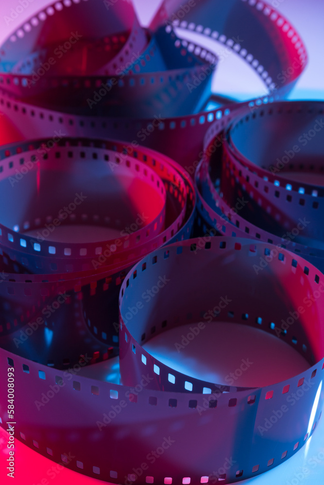 35 mm film curls illuminated with red and blue colored lights.
