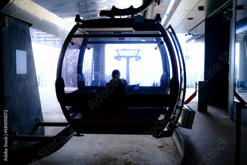 modern mountain cable car in the starting station, off-season, mid-day, early spring, backlight