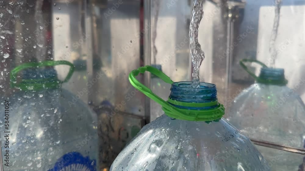 water is poured into a plastic bottle from a vending machine with clean water water is poured into a plastic bottle from a vending machine with clean water