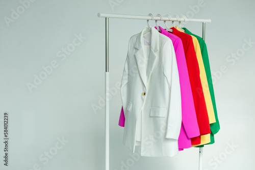 Multi-colored bright jackets on a hanger on a white background. © Eno1