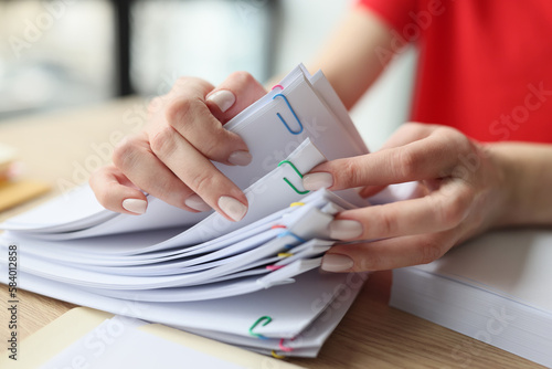 Woman looks for necessary materials sitting at wooden table
