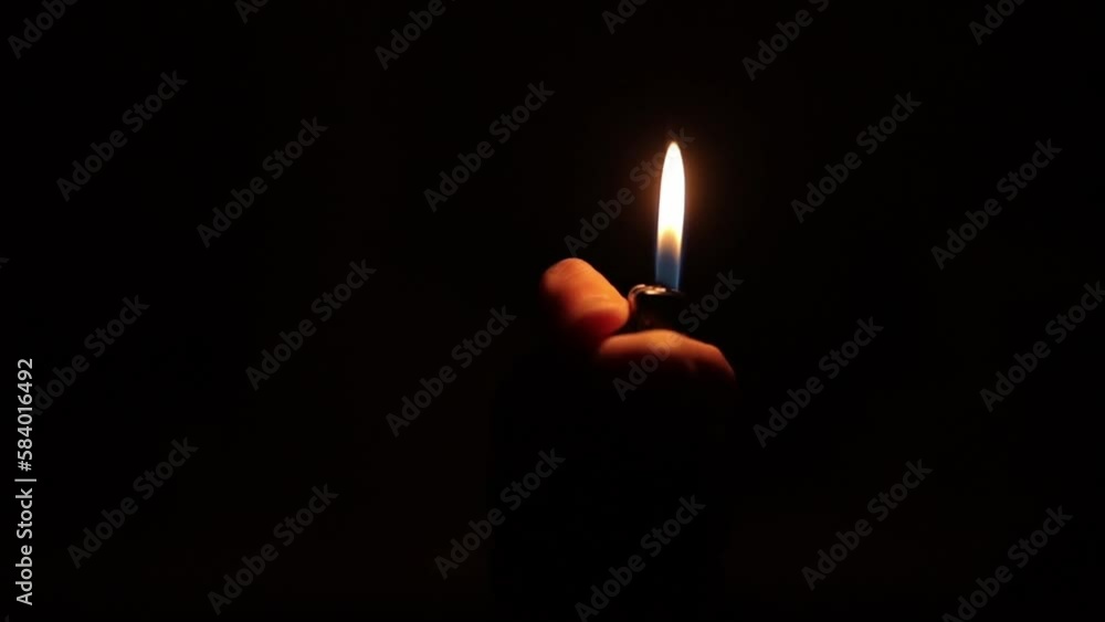 Man's hand with a gas lighter. A man kindles a fire. slow motion footage. slow motion light fire gas lighter in the dark. a lighter flame on a black background. ignited by sparks. The lighter. Man's hand with a gas lighter. A man kindles a fire. slow motion footage. slow motion light fire gas lighter in the dark. a lighter flame on a black background. ignited by sparks. The lighter.