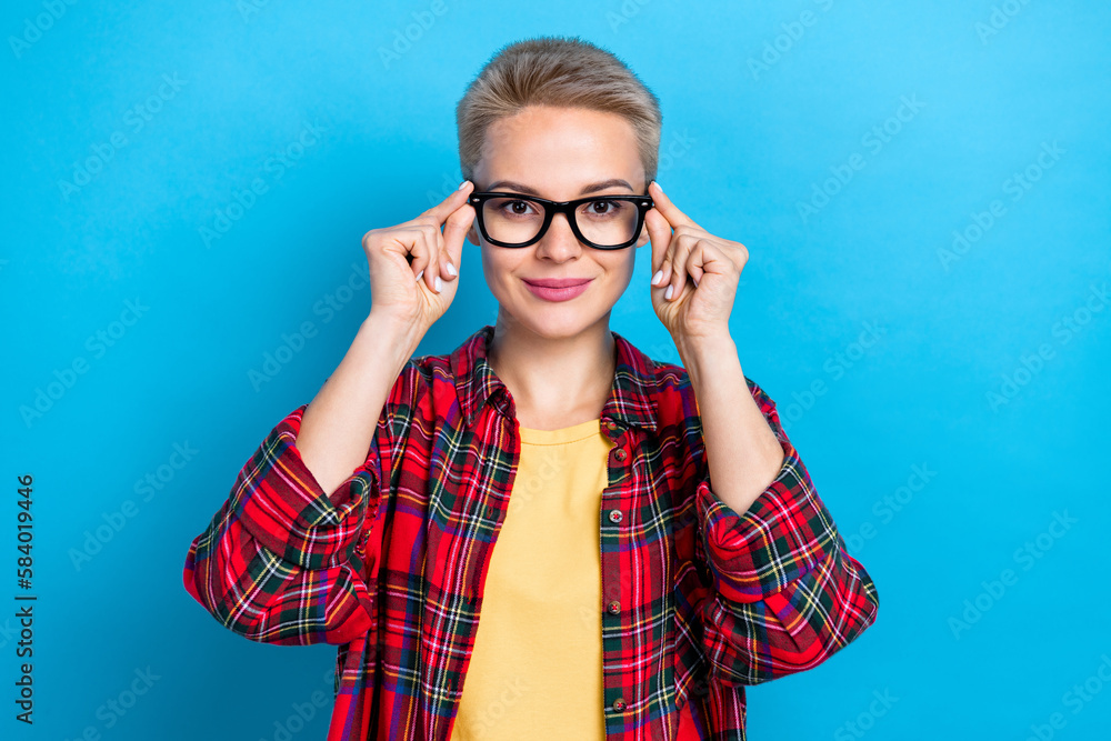 Portrait of gorgeous good mood woman with short hairdo wear checkered shirt fingers touching eyewear isolated on blue color background Portrait of gorgeous good mood woman with short hairdo wear checkered shirt fingers touching eyewear isolated on blue color background