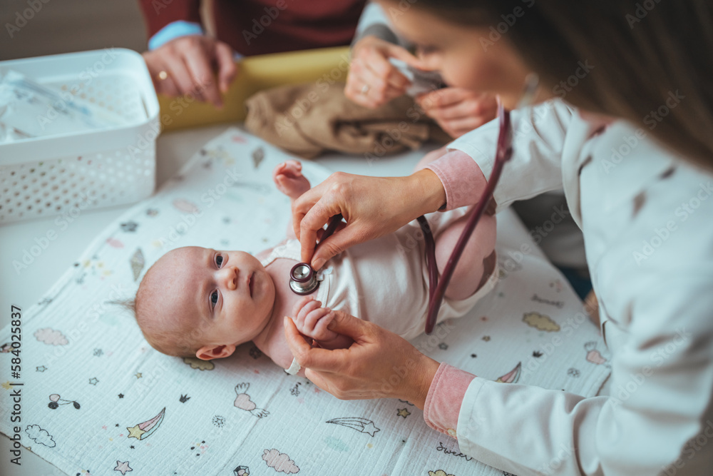 Doctor examining small kid with stethoscope in clinic. Doctor listening small childs lungs with stethoscope. Close up of pediatrician hand using a stethoscope to listen and checking heartbeat. Doctor examining small kid with stethoscope in clinic. Doctor listening small childs lungs with stethoscope. Close up of pediatrician hand using a stethoscope to listen and checking heartbeat.