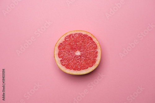 Juicy organic grapefruit cut in half on a pink background. Cool minimal flat lay, copy space. Healty breakfast or diet concept. (ID: 584031014)