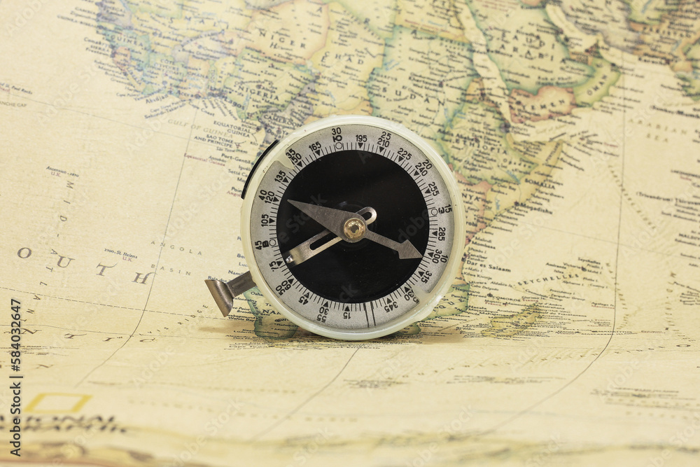 Classic round compass on background of old vintage map