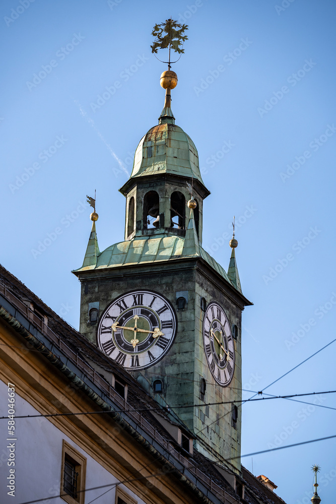 Beautiful church tower with lion decoration and clock tower visible from the street in the city of Graz, Austria