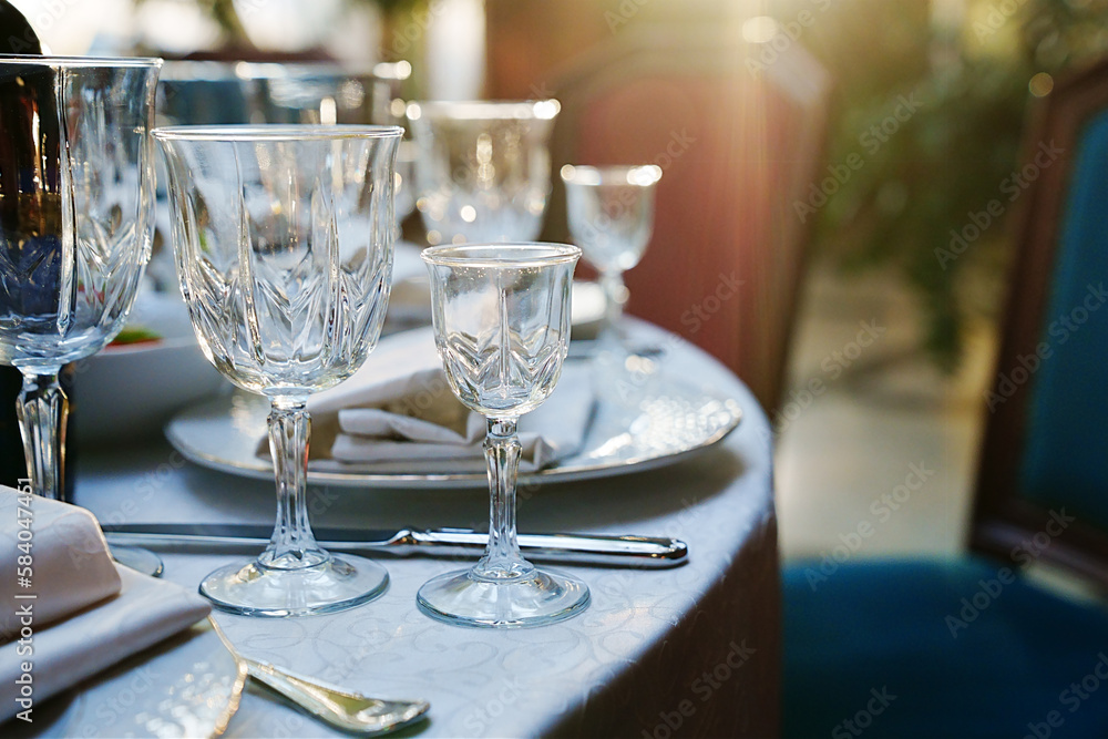 Fototapeta premium empty wine glasses on the table.table setting for a festive dinner. solar glare.