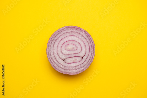 Organic sliced red onion on a yellow background. Cool flat lay, copy space