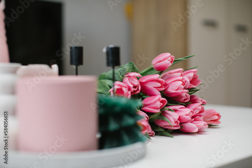 Bouquet of pink tulips on a white table in the room. Copy space. 