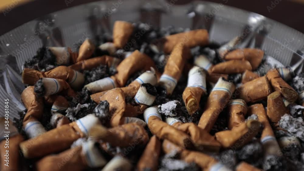 Cigarettes in an ashtray, ashes, many smoked cigarettes. A strong passion for smoking. Harmful