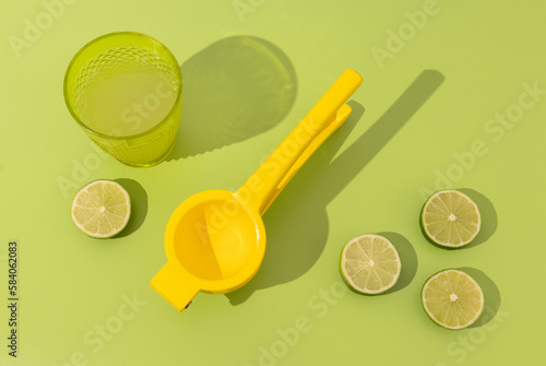Принти на полотні Top view of freshly made lemonade with limes and lemon squeezer, sharp shadows,