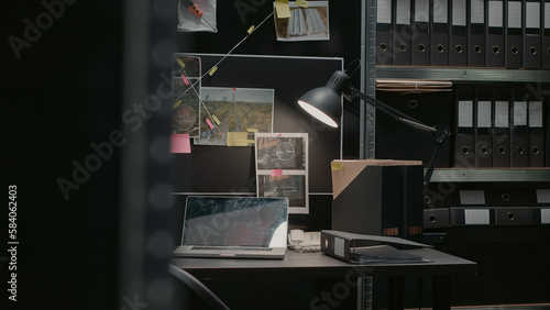 Detective board with clues over desk in police archive, crime scene photos connected on wall and case files in investigation office. Empty incident room with forensic evidence and surveillance.