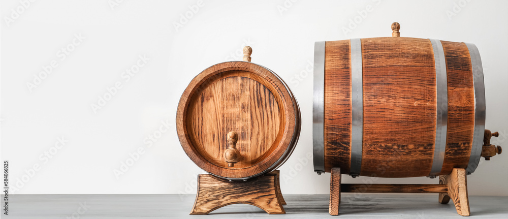 Naklejka premium Wooden barrels on light background with space for text