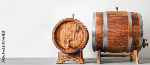 Fototapeta Naklejka Na Ścianę i Meble -  Wooden barrels on light background with space for text
