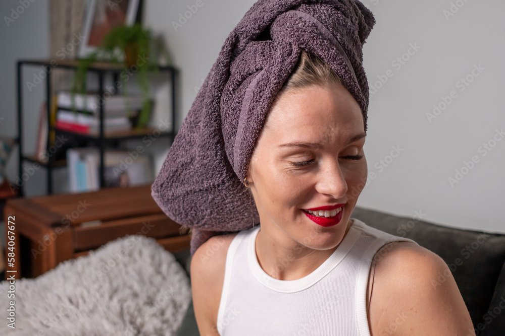 The smiling young woman with red lips and white T-shirt just washed her hair. The smiling young woman with red lips and white T-shirt just washed her hair.
