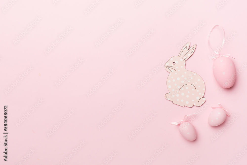 Cute easter bunny and eggs on color background, top view