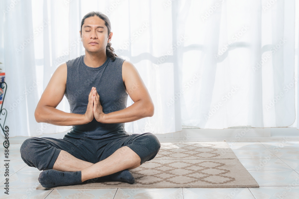 A man do Yoga indoors, there is plenty of light. A man do Yoga indoors, there is plenty of light.