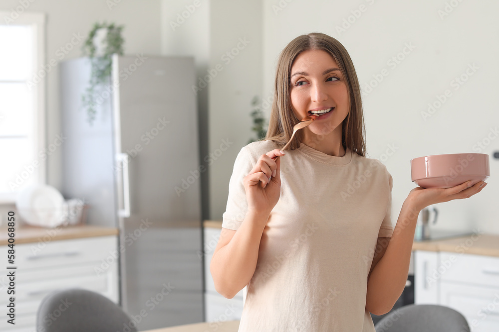 Beautiful woman with golden spoon and bowl in kitchen Beautiful woman with golden spoon and bowl in kitchen