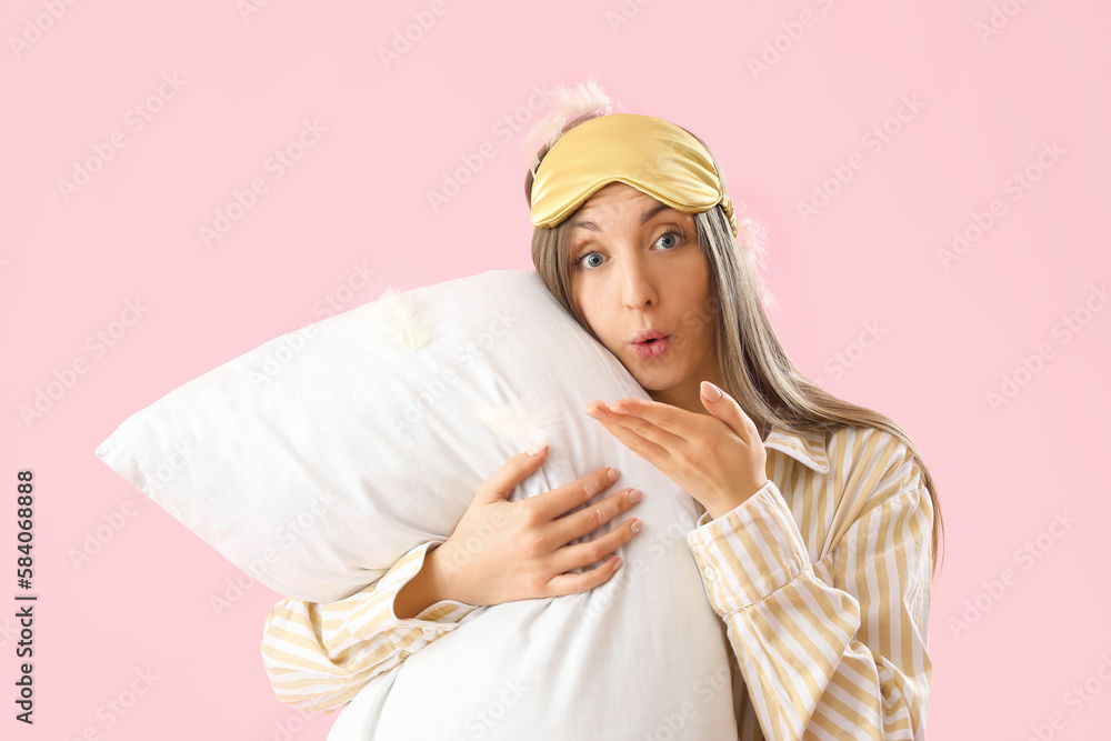 Young woman with sleeping mask, pillow and feathers on pink background Young woman with sleeping mask, pillow and feathers on pink background