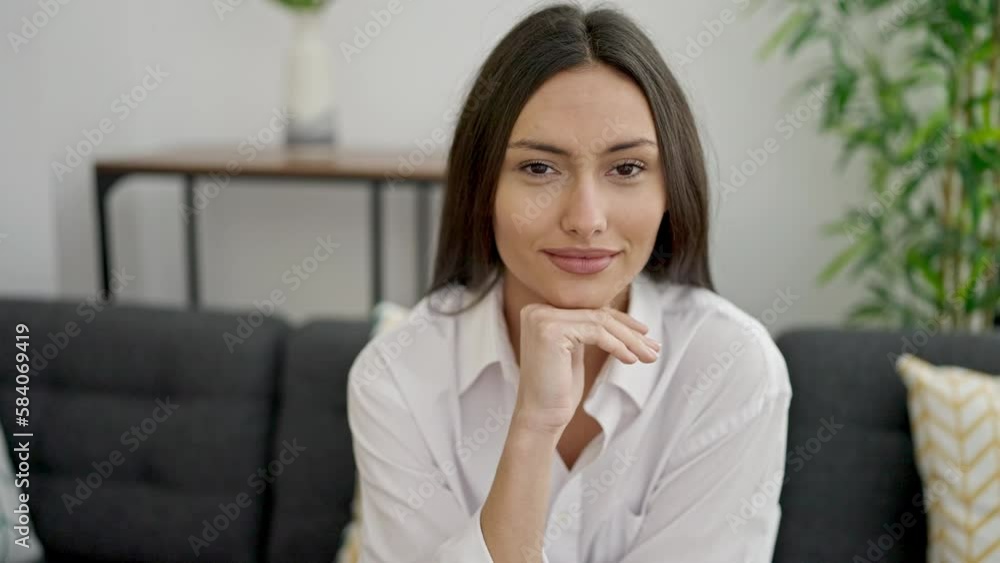 Young beautiful hispanic woman smiling confident sitting on sofa at home Young beautiful hispanic woman smiling confident sitting on sofa at home